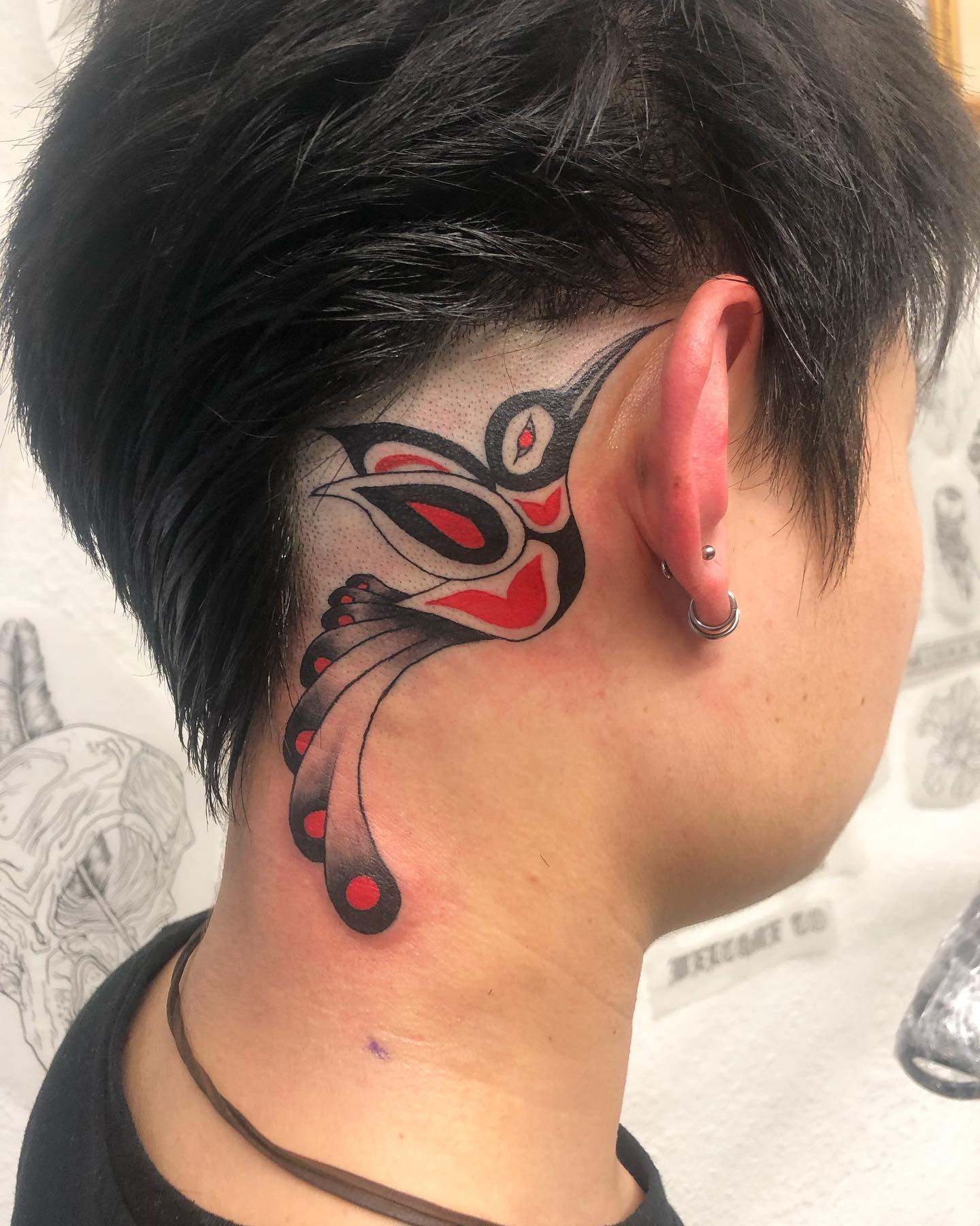 Diseño de tatuaje de pájaro detrás de la oreja