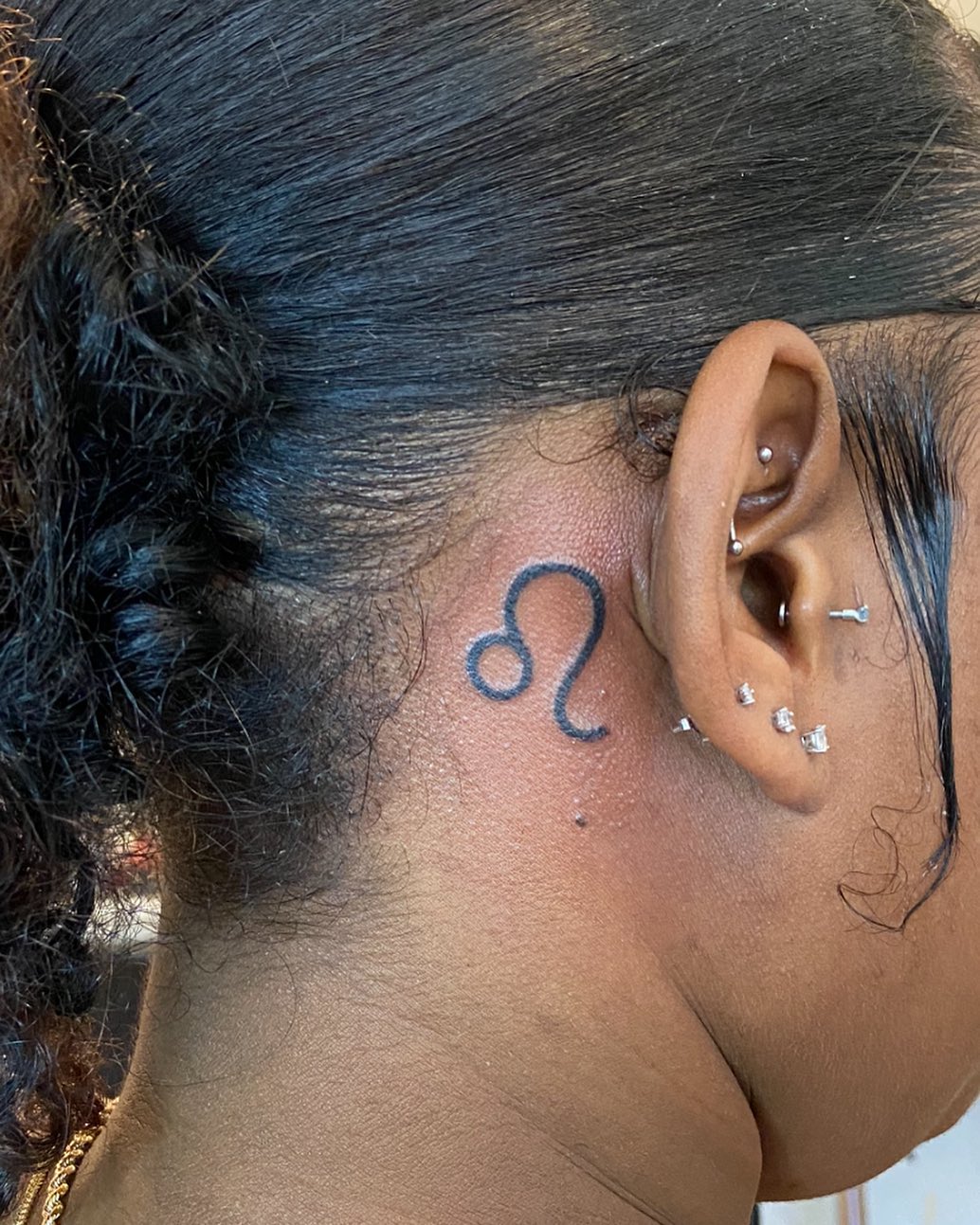 Diseño de tatuaje de zodiaco detrás de la oreja.