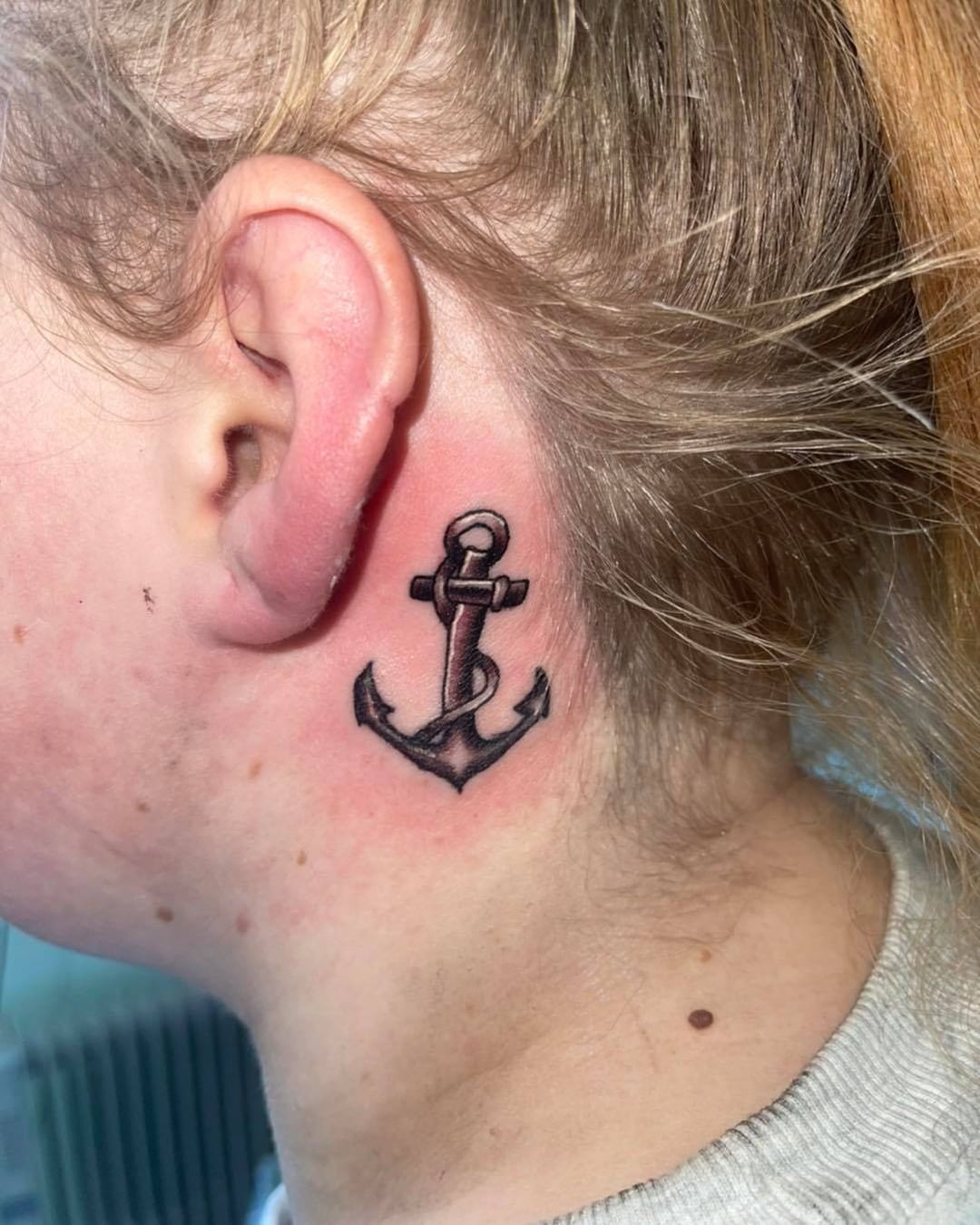 Tatuaje de ancla detrás de la oreja