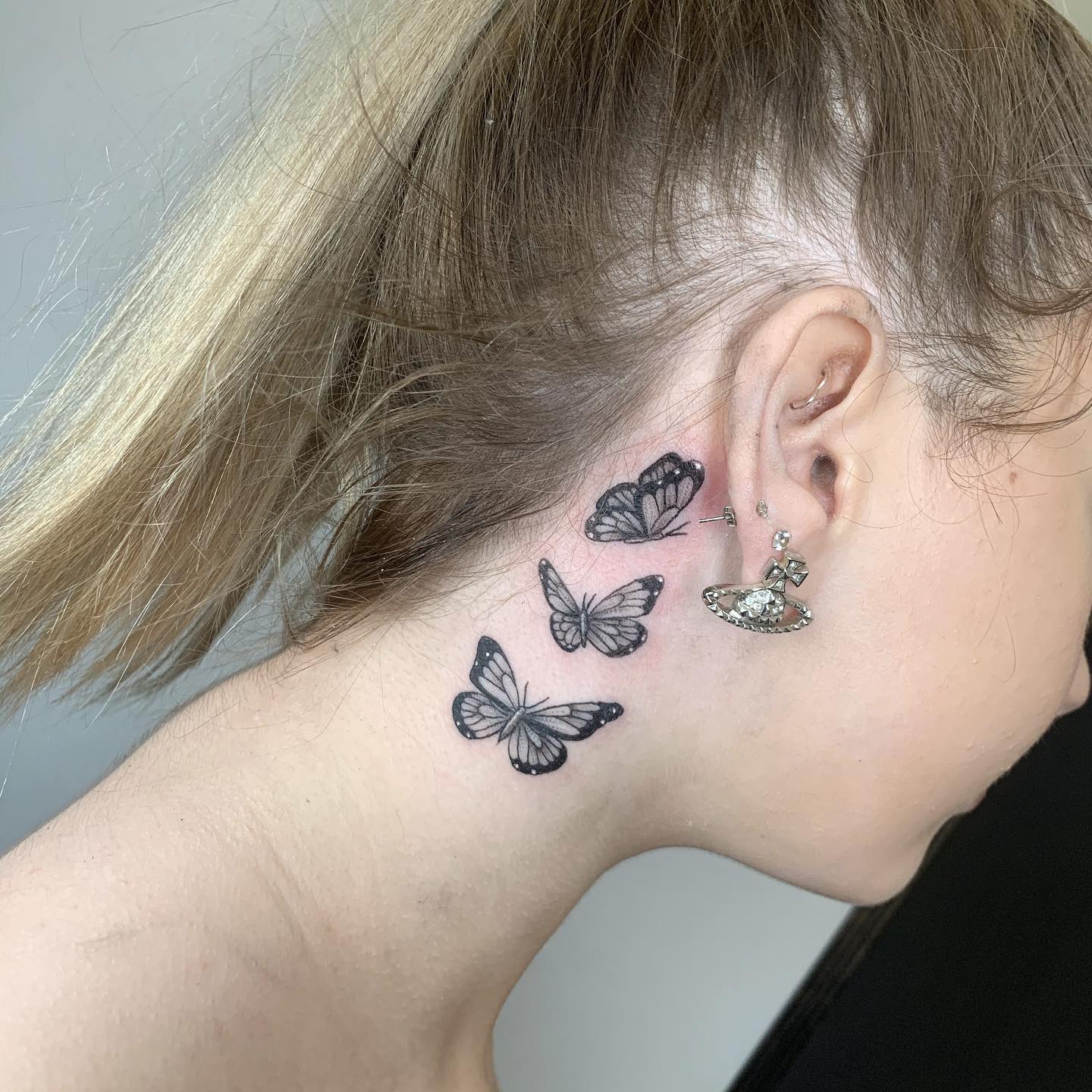 Tatuaje de mariposas detrás de la oreja