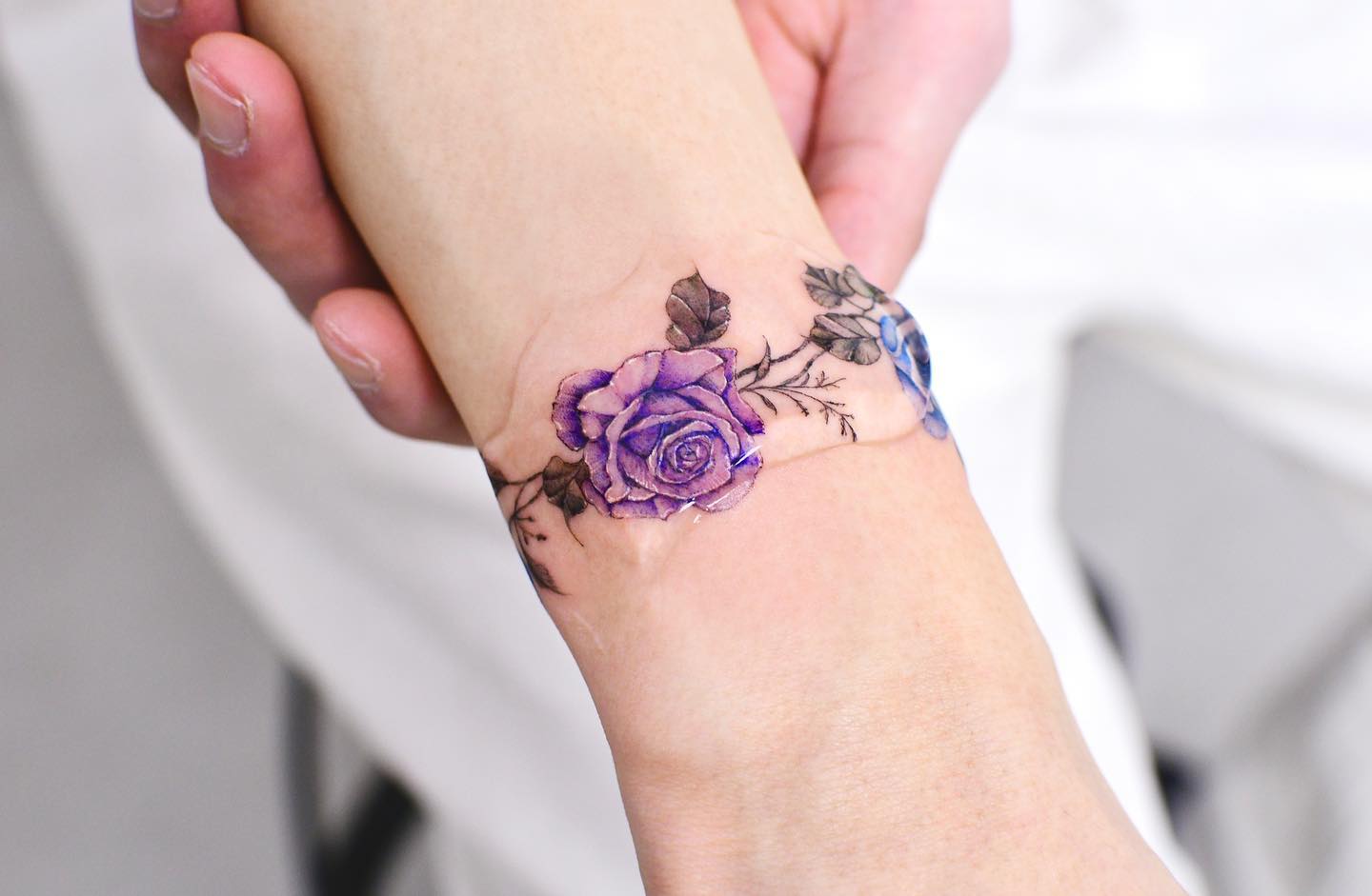 Tatuaje de muñeca de flores moradas