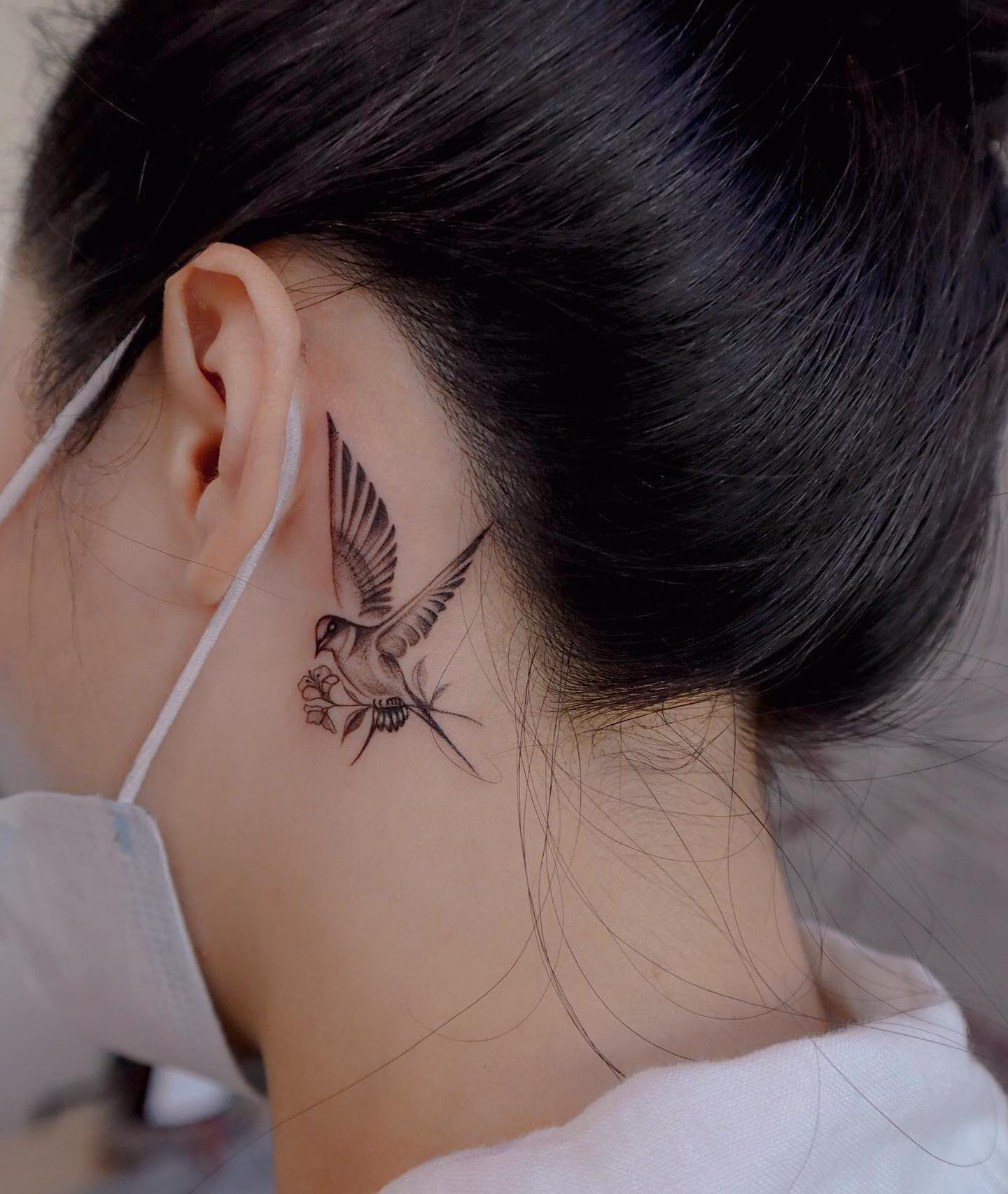 Tatuaje de pájaro detrás de la oreja