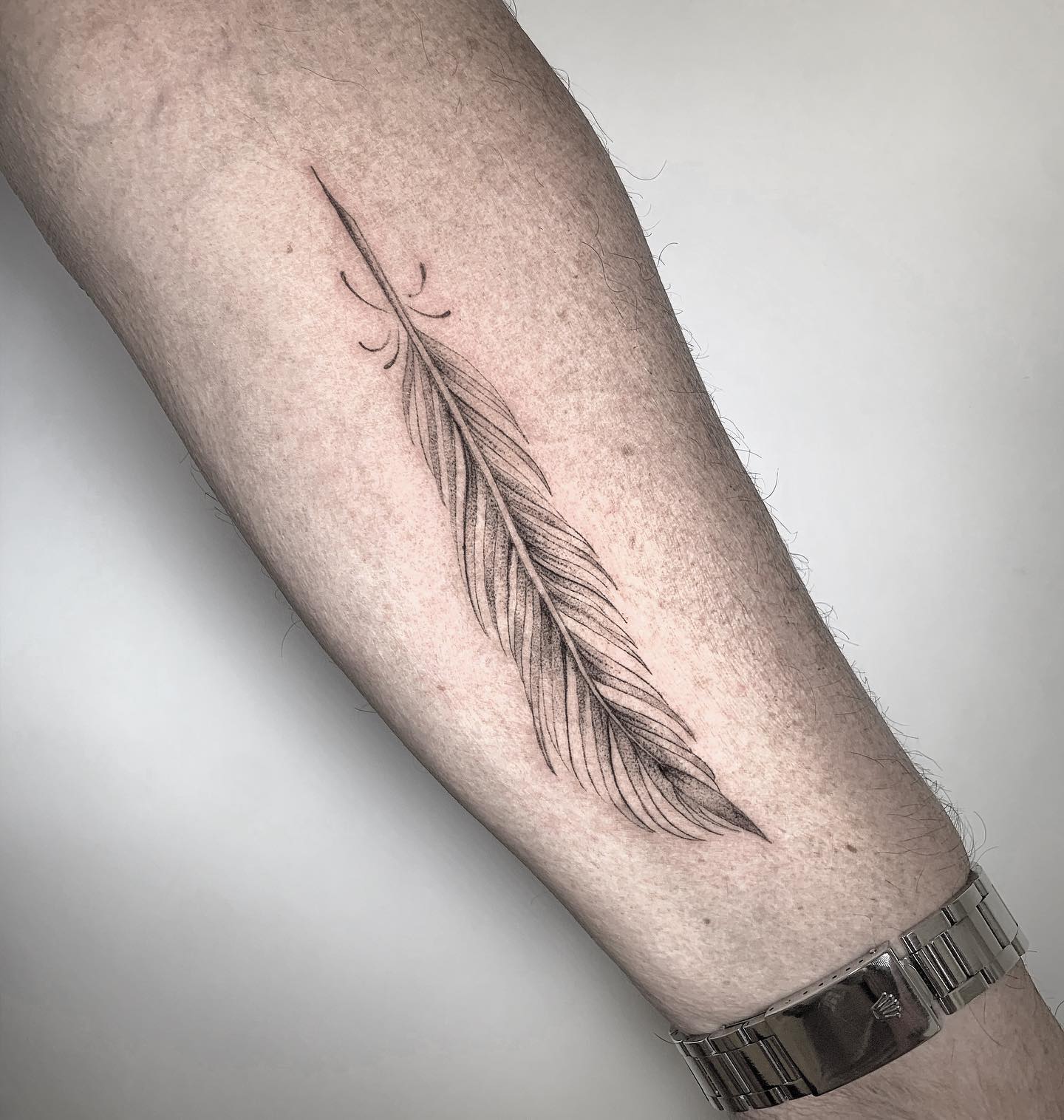 Tatuaje de plumas en puntillismo