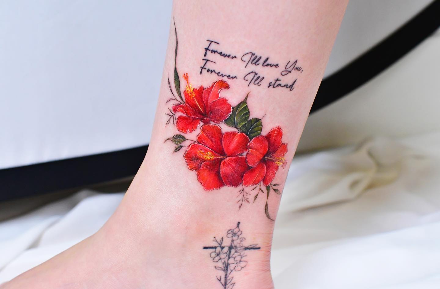Tatuaje de tobillo de flor roja.