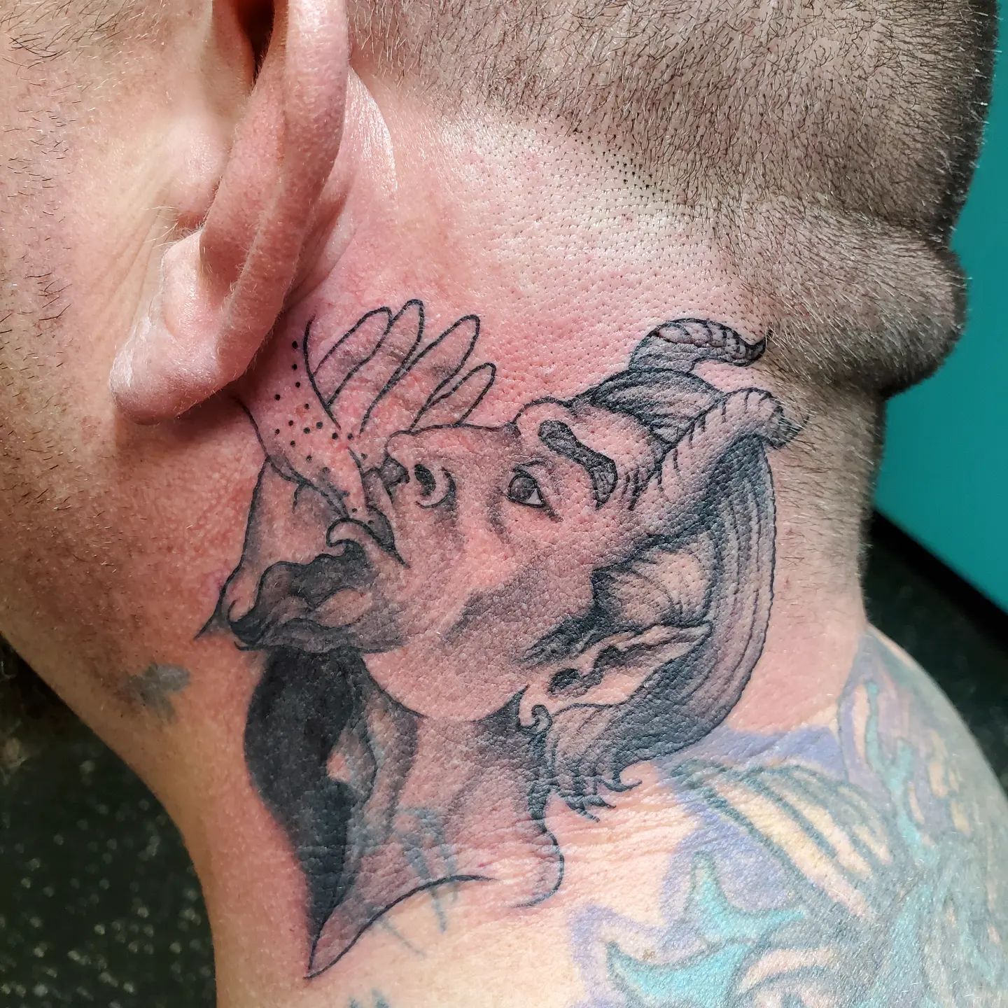 Tatuaje del diablo detrás de la oreja.