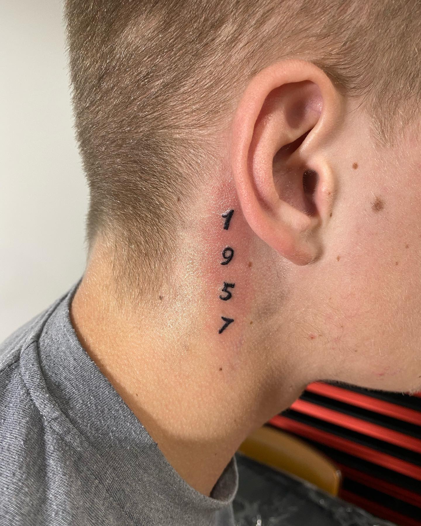 Tatuaje detrás de la oreja, números impresos
