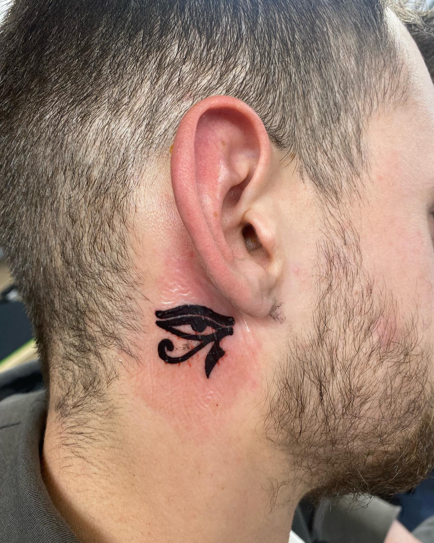 Tatuaje detrás de la oreja inspirado en Egipto