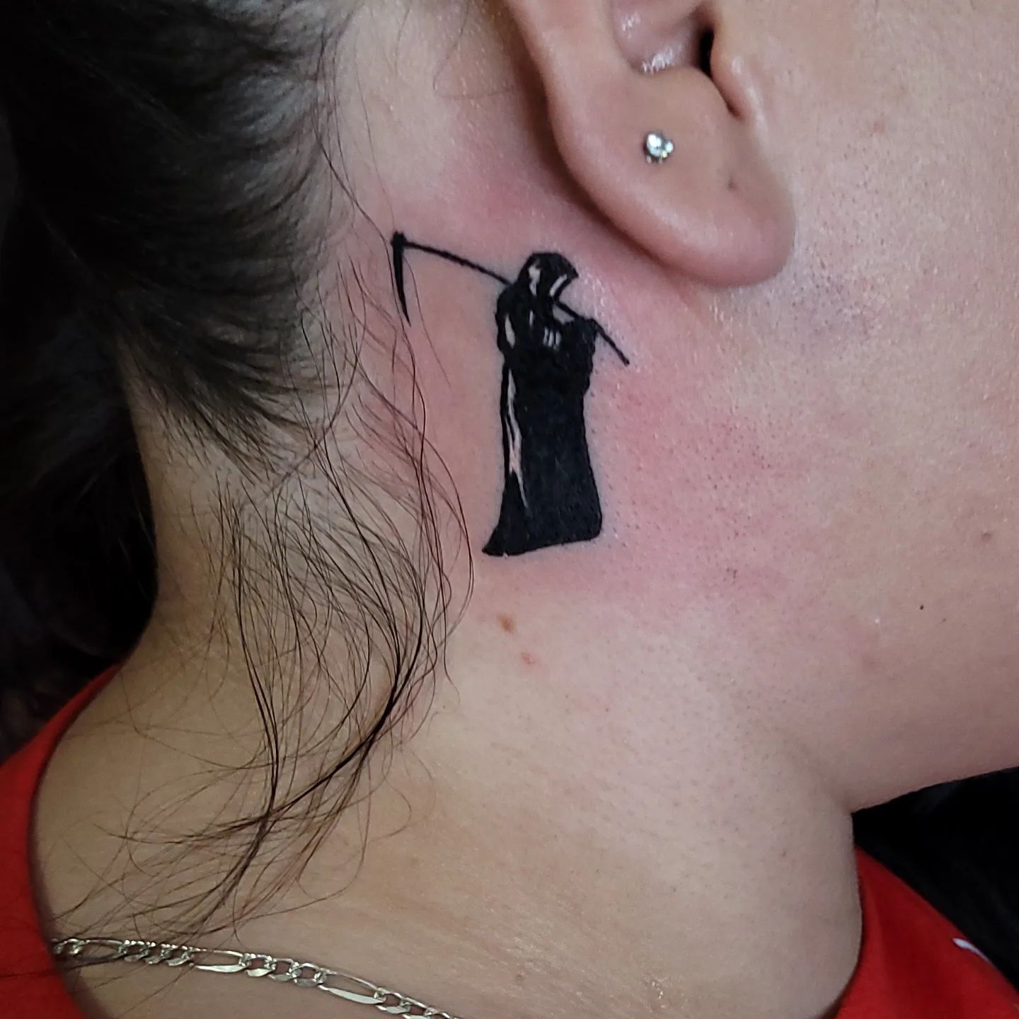 Tatuaje detrás de la oreja inspirado en la muerte