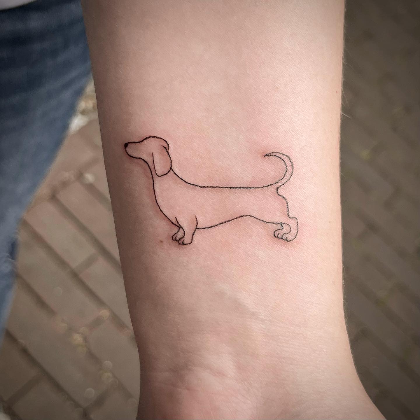 Tatuaje fresco de perro en la muñeca