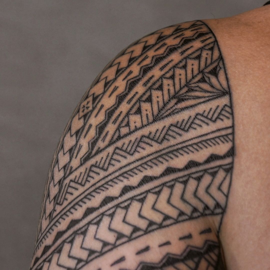 Símbolos de tatuaje samoano en el hombro.