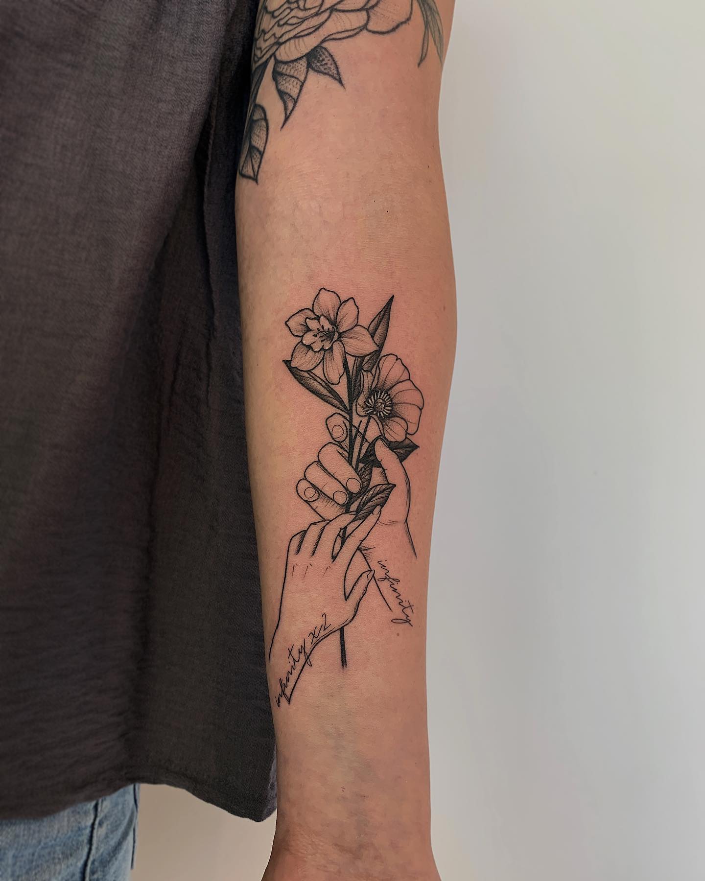 Tatuaje de narciso negro en el brazo.
