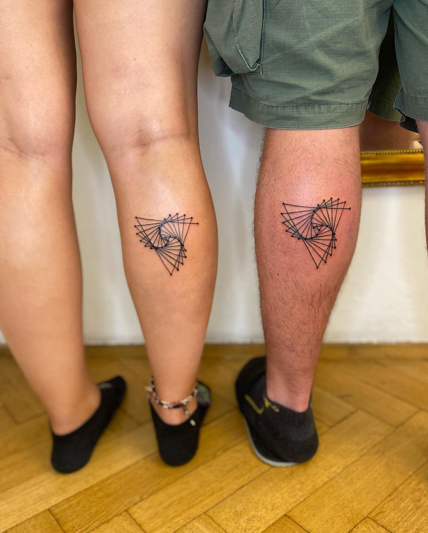 Tatuajes combinados de pareja en las piernas.