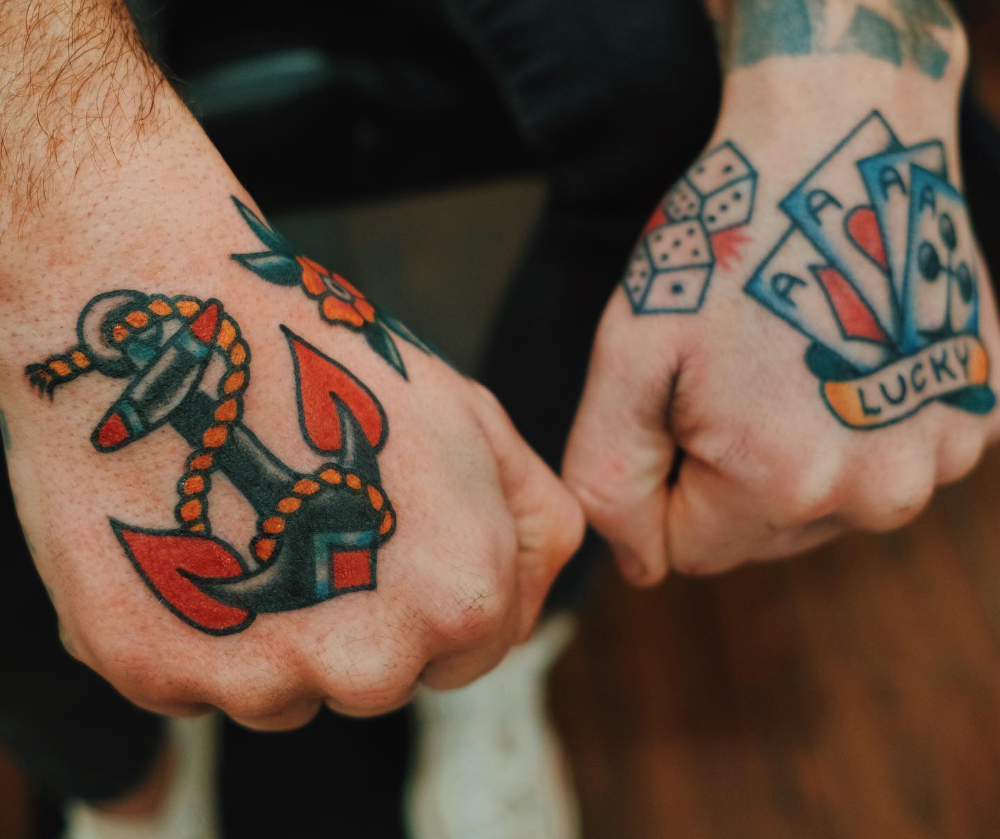 Ancla y tatuaje de mano con cartas.