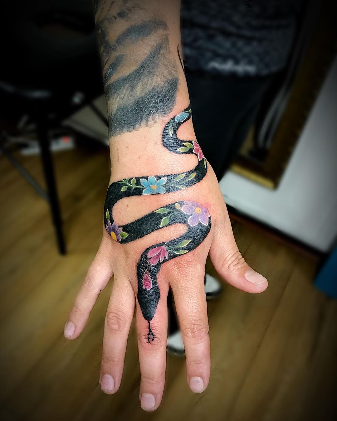 Diseño de serpiente y flor en la mano.