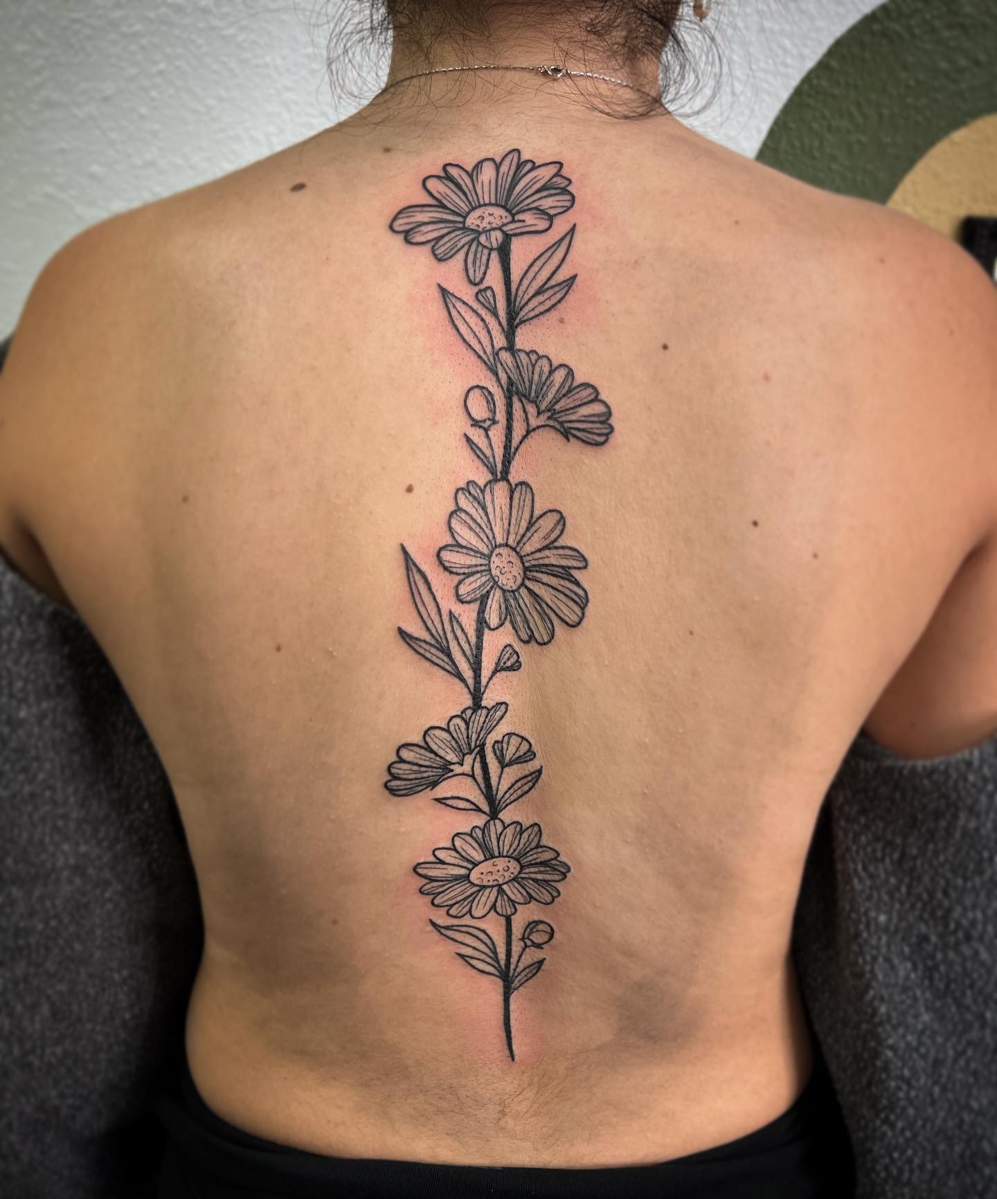 Gran tatuaje detallado de margarita en la espalda.