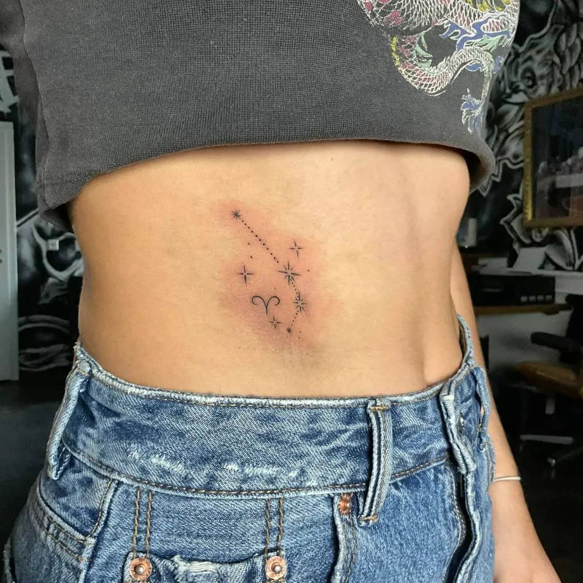 Tatuaje de Aries en el estómago.