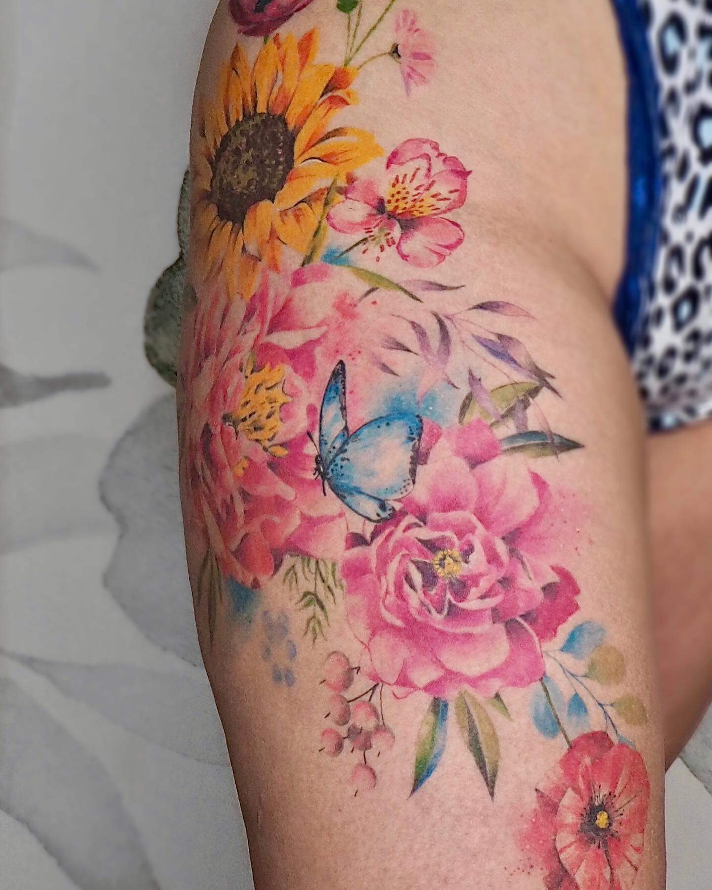Tatuaje de cadera colorido y artístico.