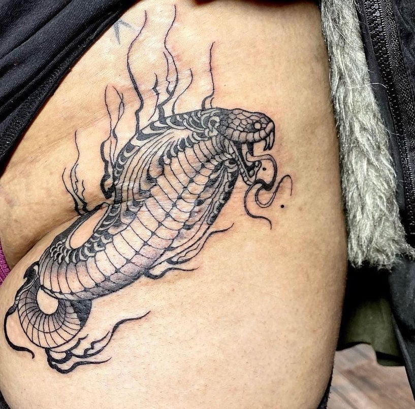 Tatuaje de cadera de serpiente negra gigante.