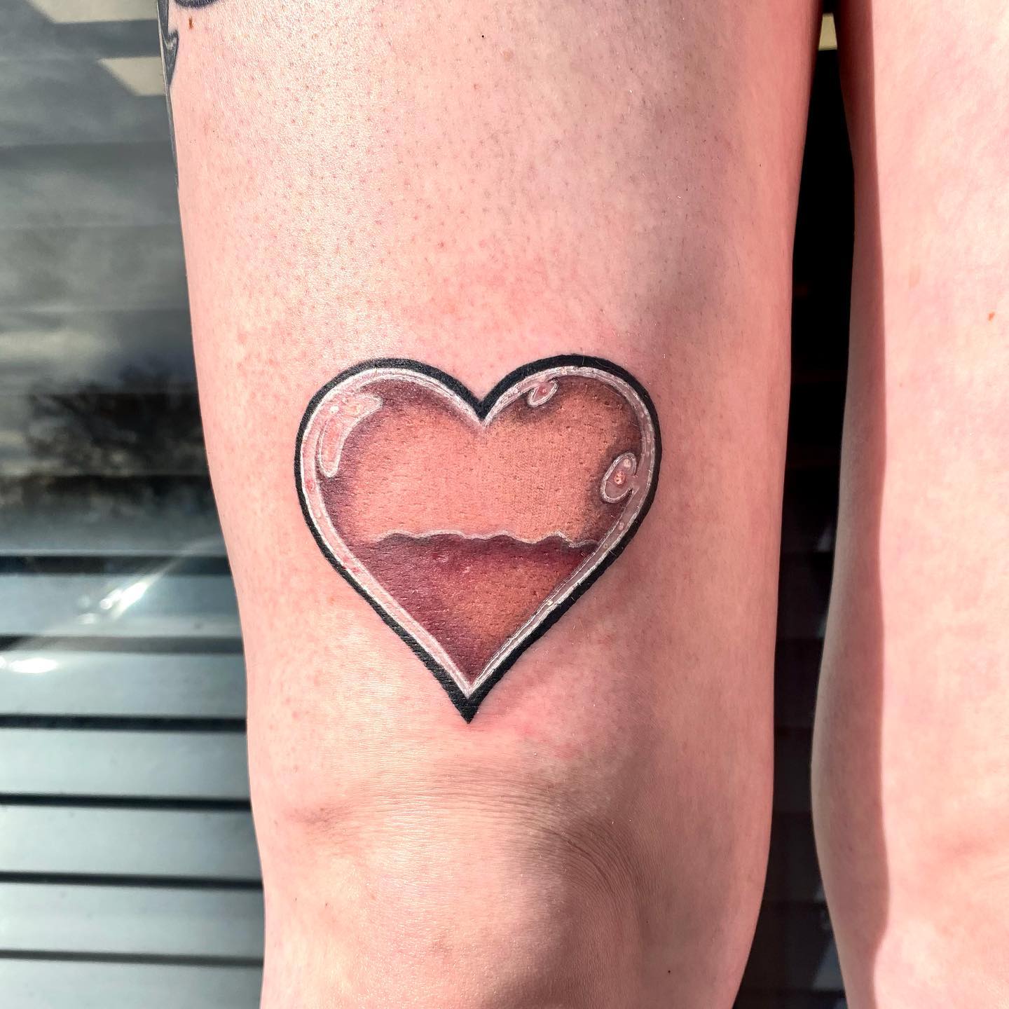 Tatuaje de corazón por encima de la rodilla