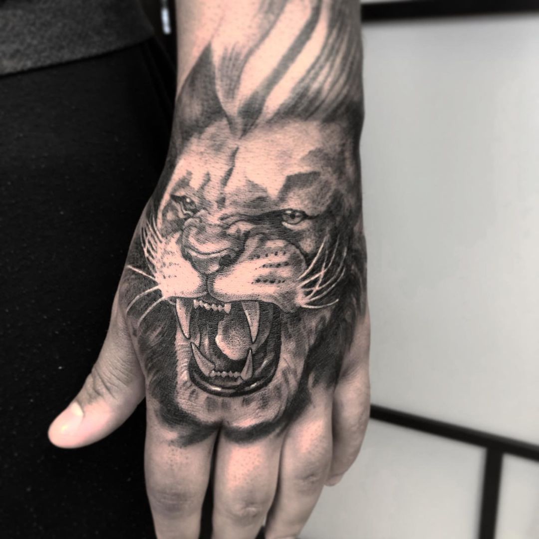 Tatuaje de león en la mano