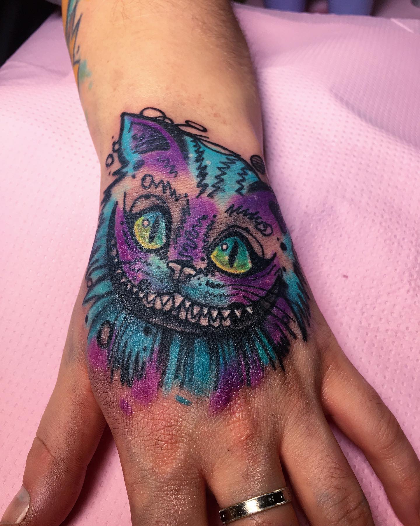 Tatuaje de mano de Gato de Cheshire.