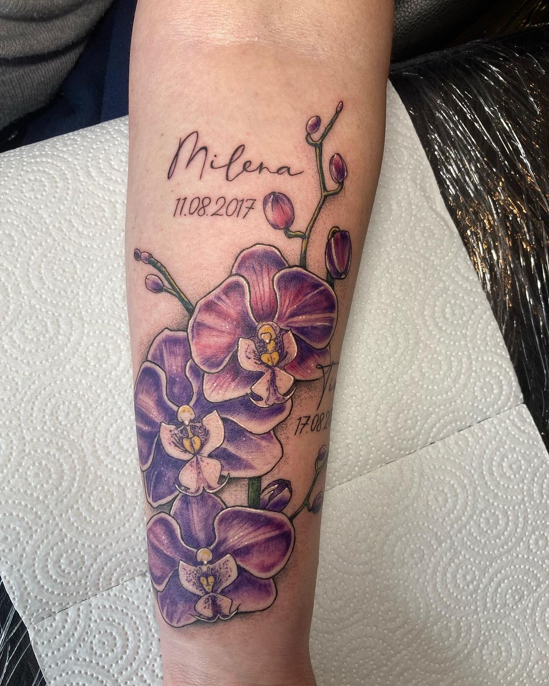 Tatuaje de orquídea con impresión de nombre.