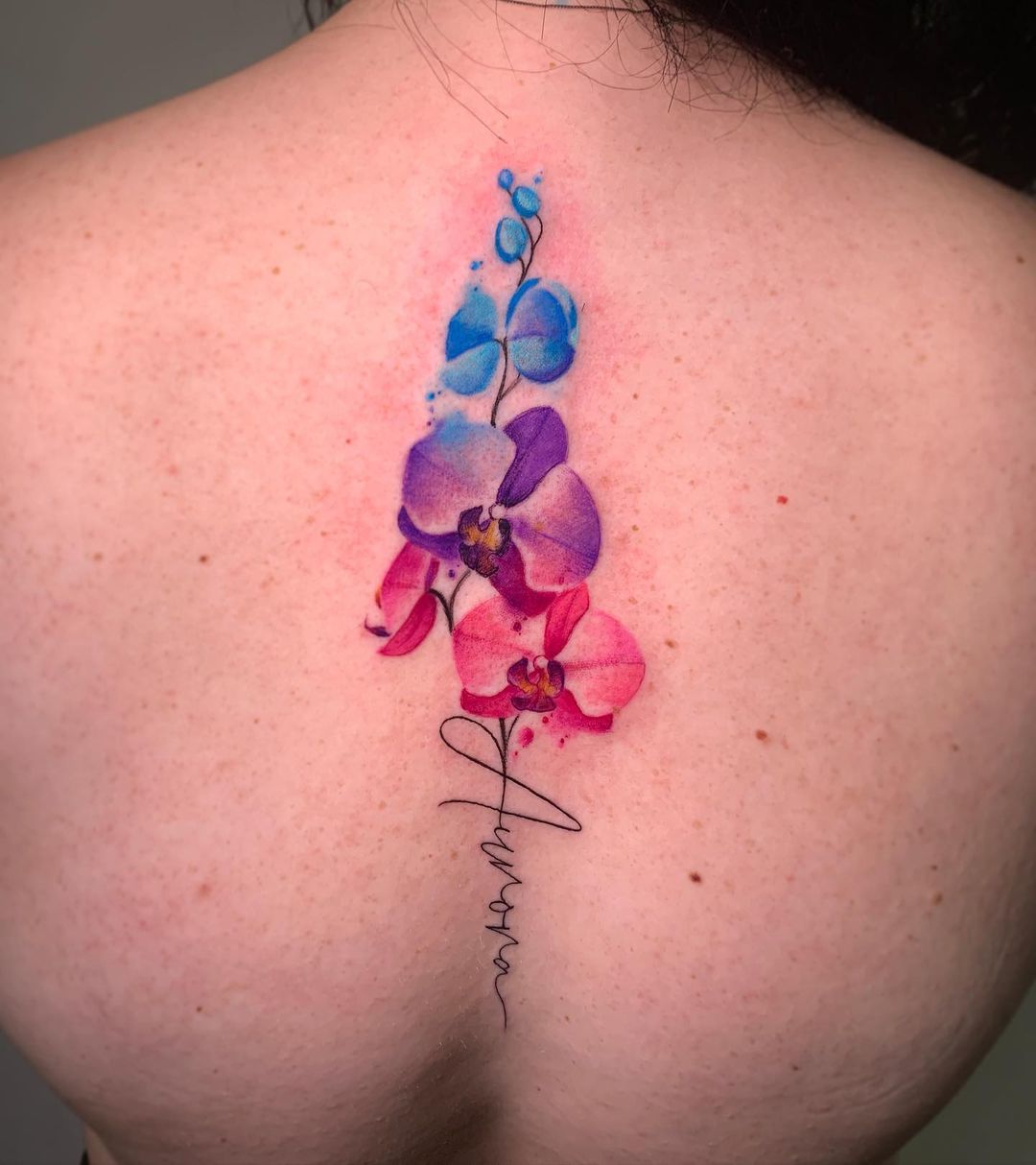 Tatuaje de orquídea en la espalda femenina