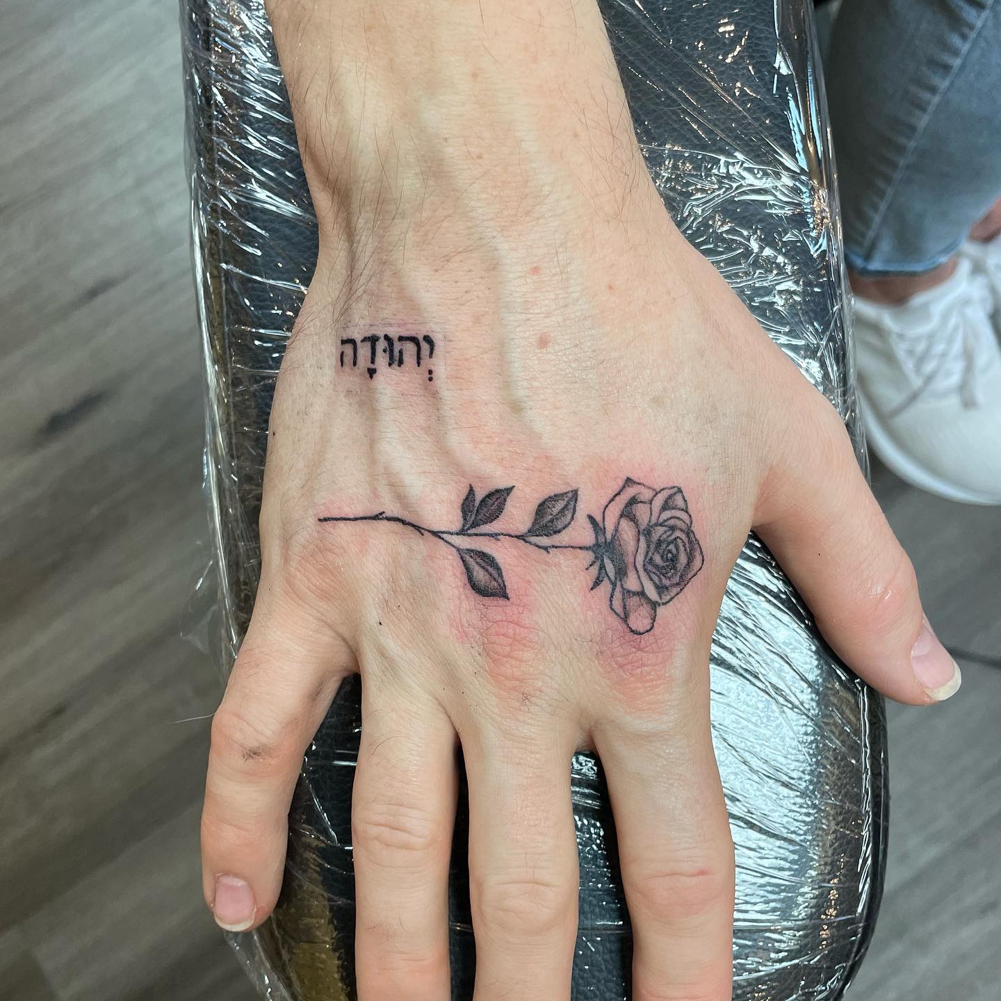 Tatuaje simple de rosa en la mano.