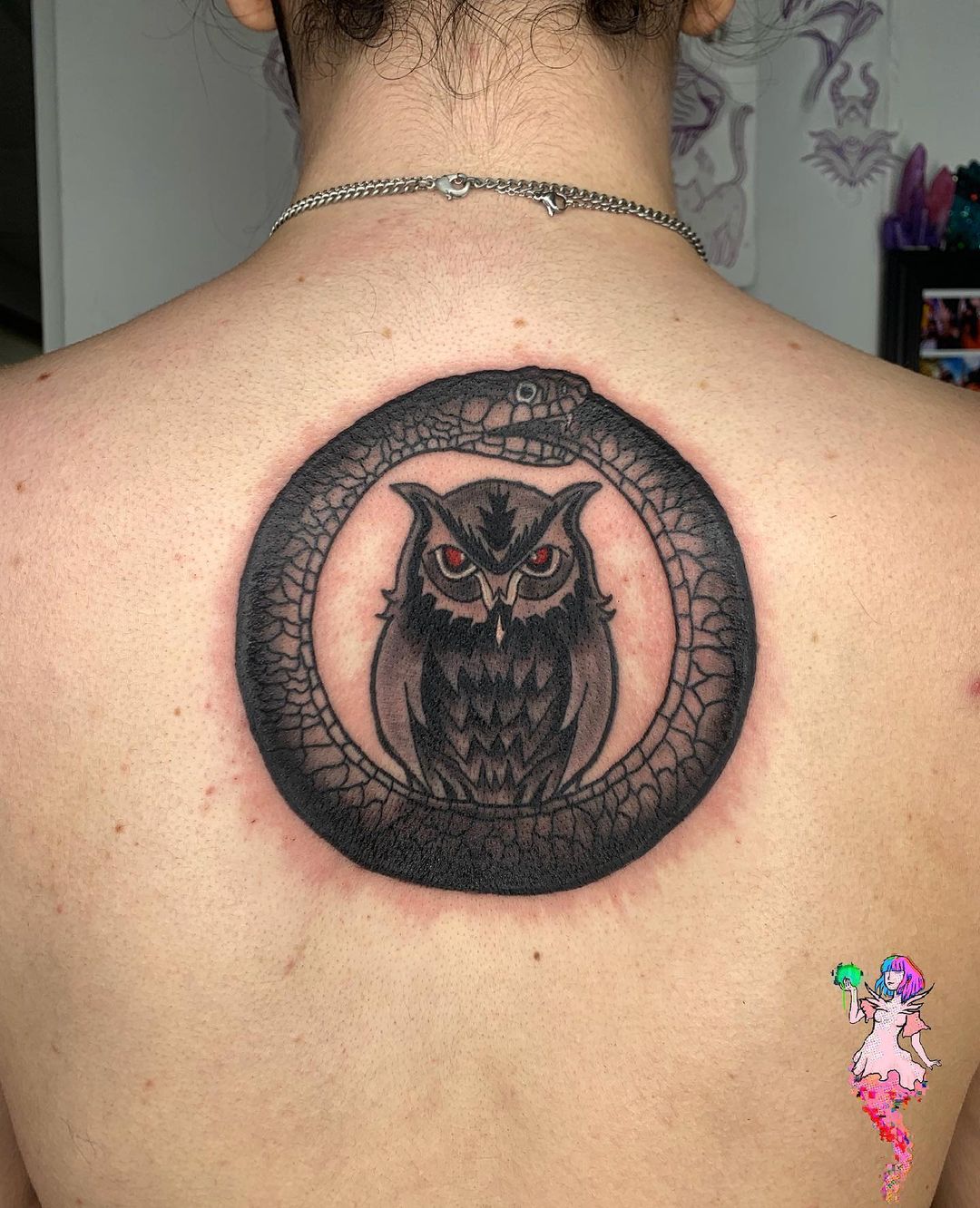 Gran tatuaje de Ouroboros en la espalda con un búho