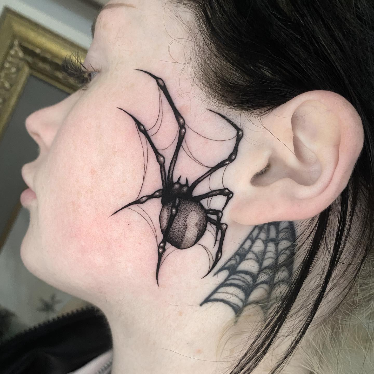 Tatuaje de araña en la cara.