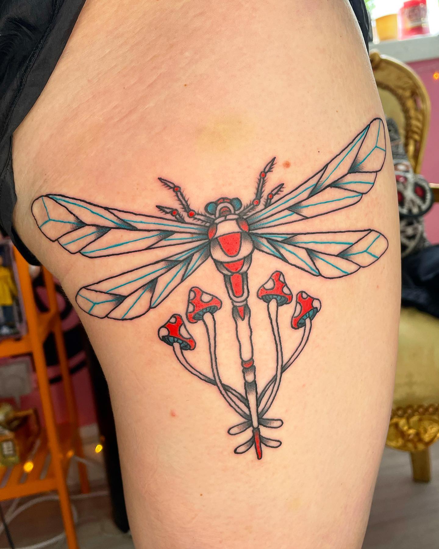 Tatuaje de libélula fresco en una pierna.