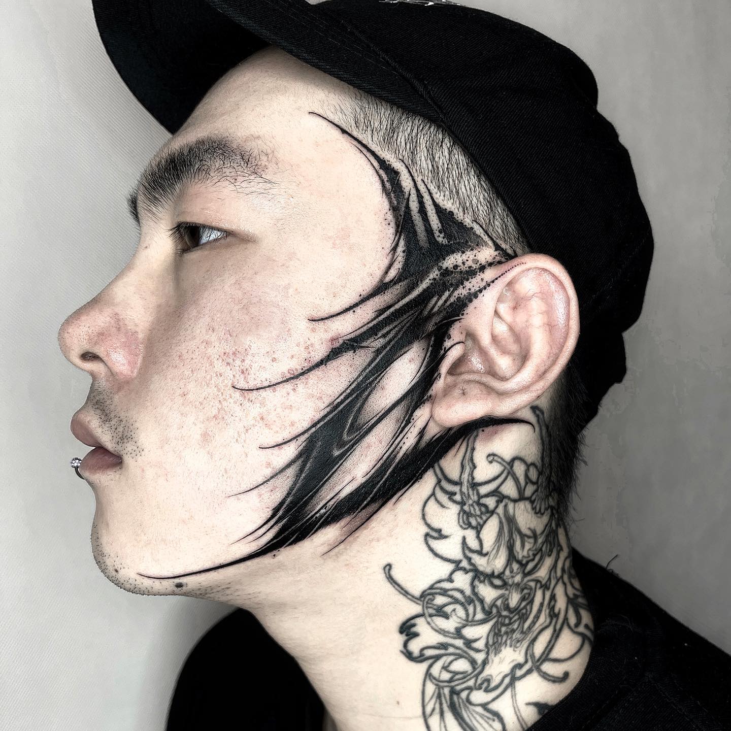 Tatuaje de línea negra en la cara