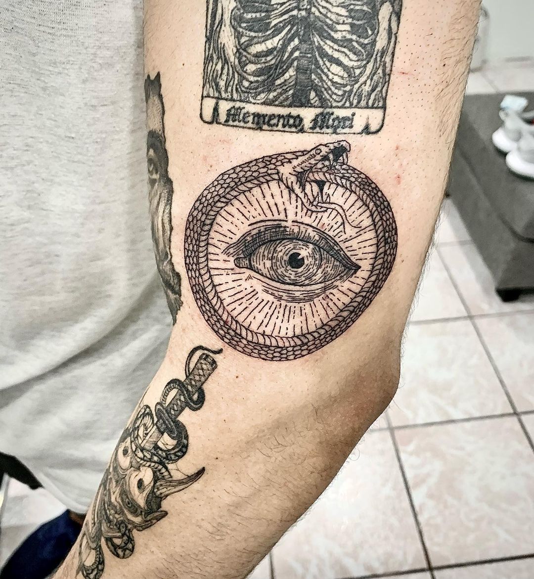 Tatuaje de Ouroboros con un símbolo del ojo