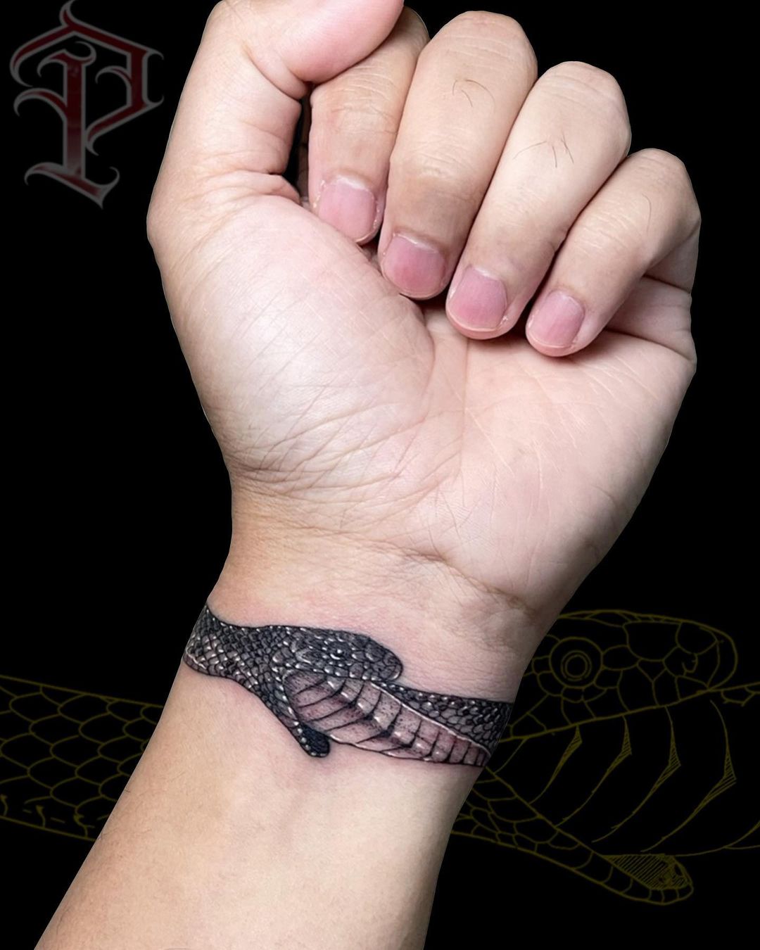 Tatuaje de Ouroboros en la muñeca con tinta negra.