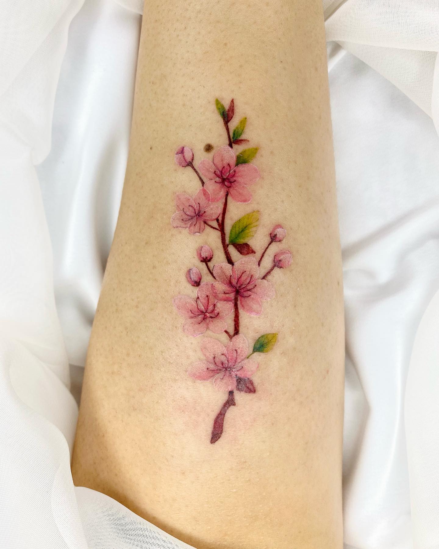 Tatuaje femenino de flor de cerezo