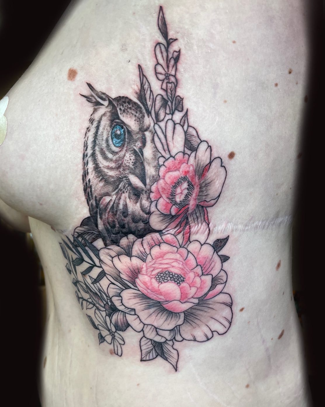 Tatuaje de búho y flor de clavel rosa.