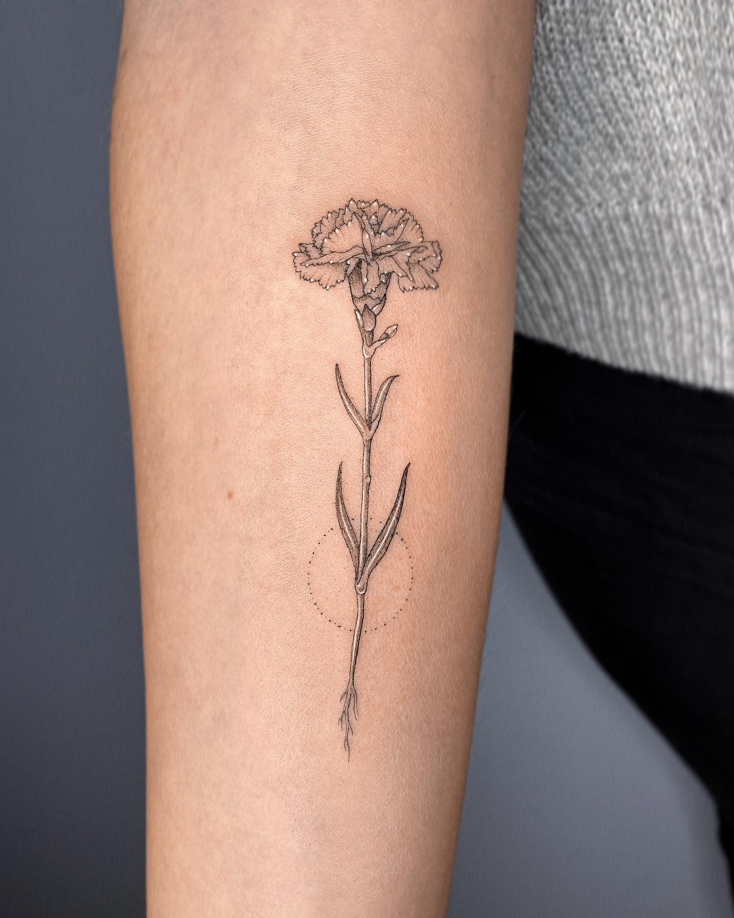 Tatuaje de flor de clavel bien hecho.