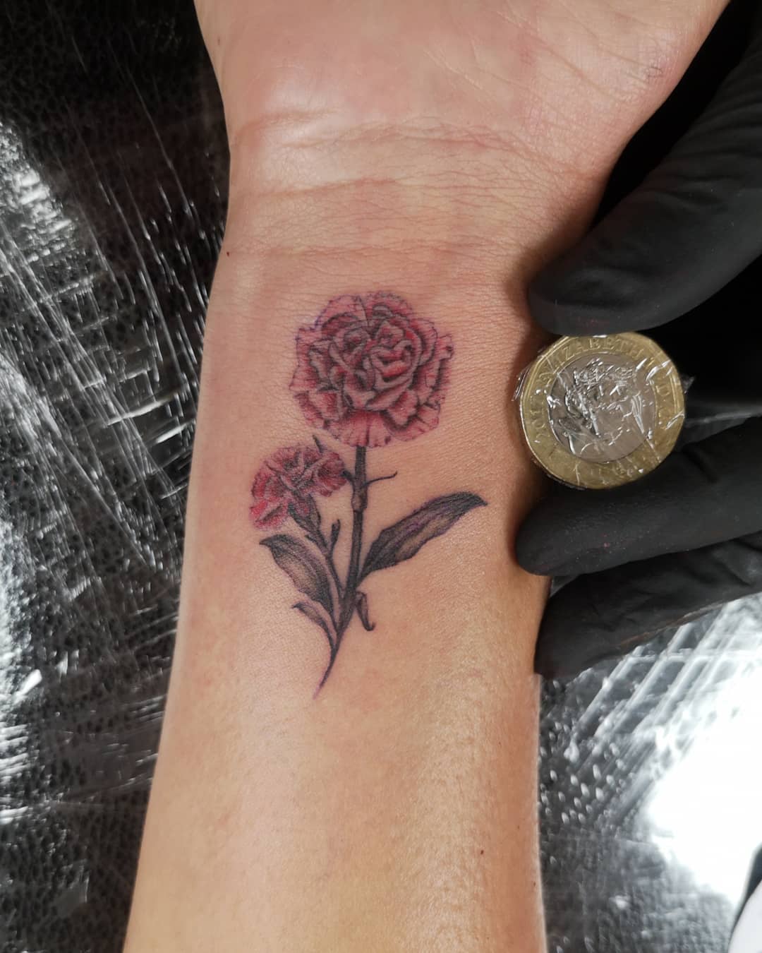 Tatuaje de Flor de Clavel en la Muñeca