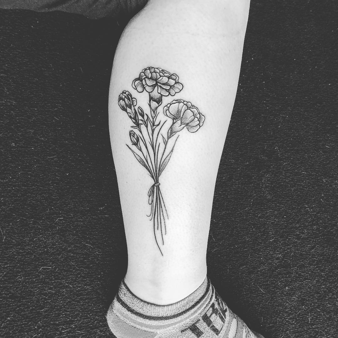Tatuaje de flor de clavel en la pantorrilla.