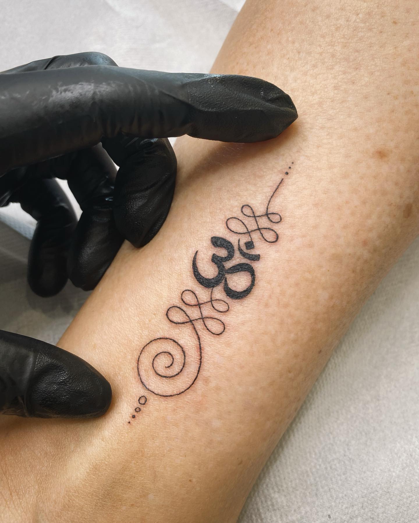 Tatuaje de símbolo Unalome y Om
