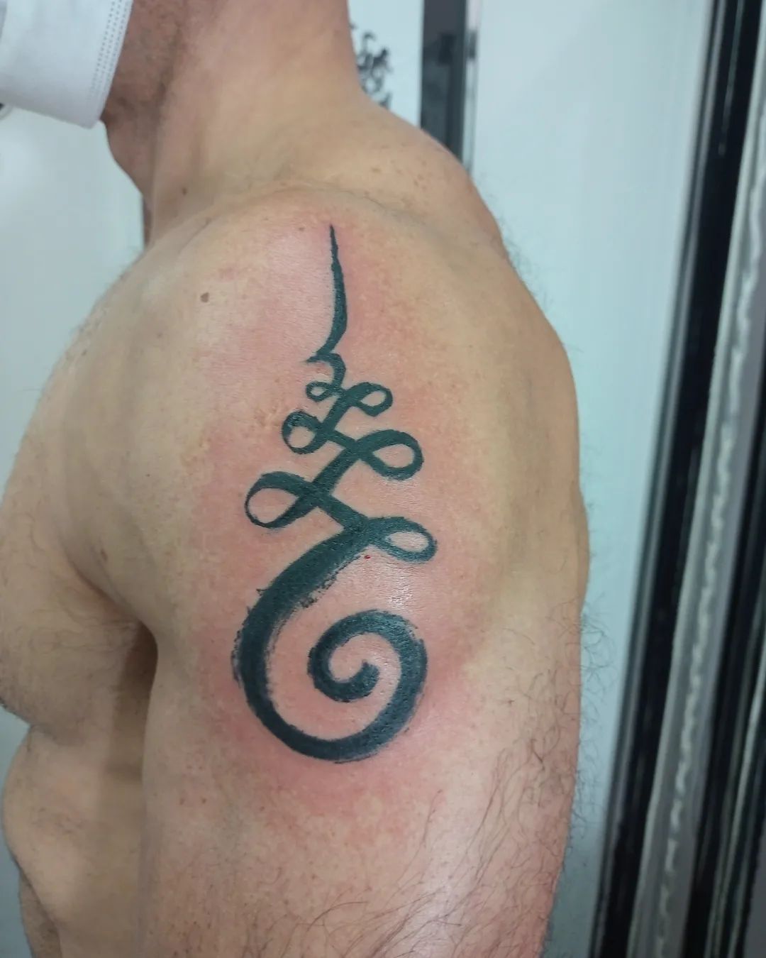 Tatuaje Unalome en el hombro
