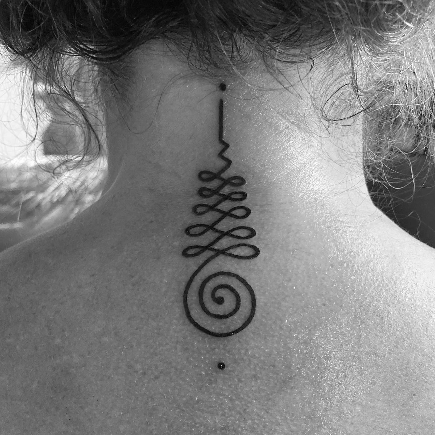 Tatuaje Unalome en la espalda.