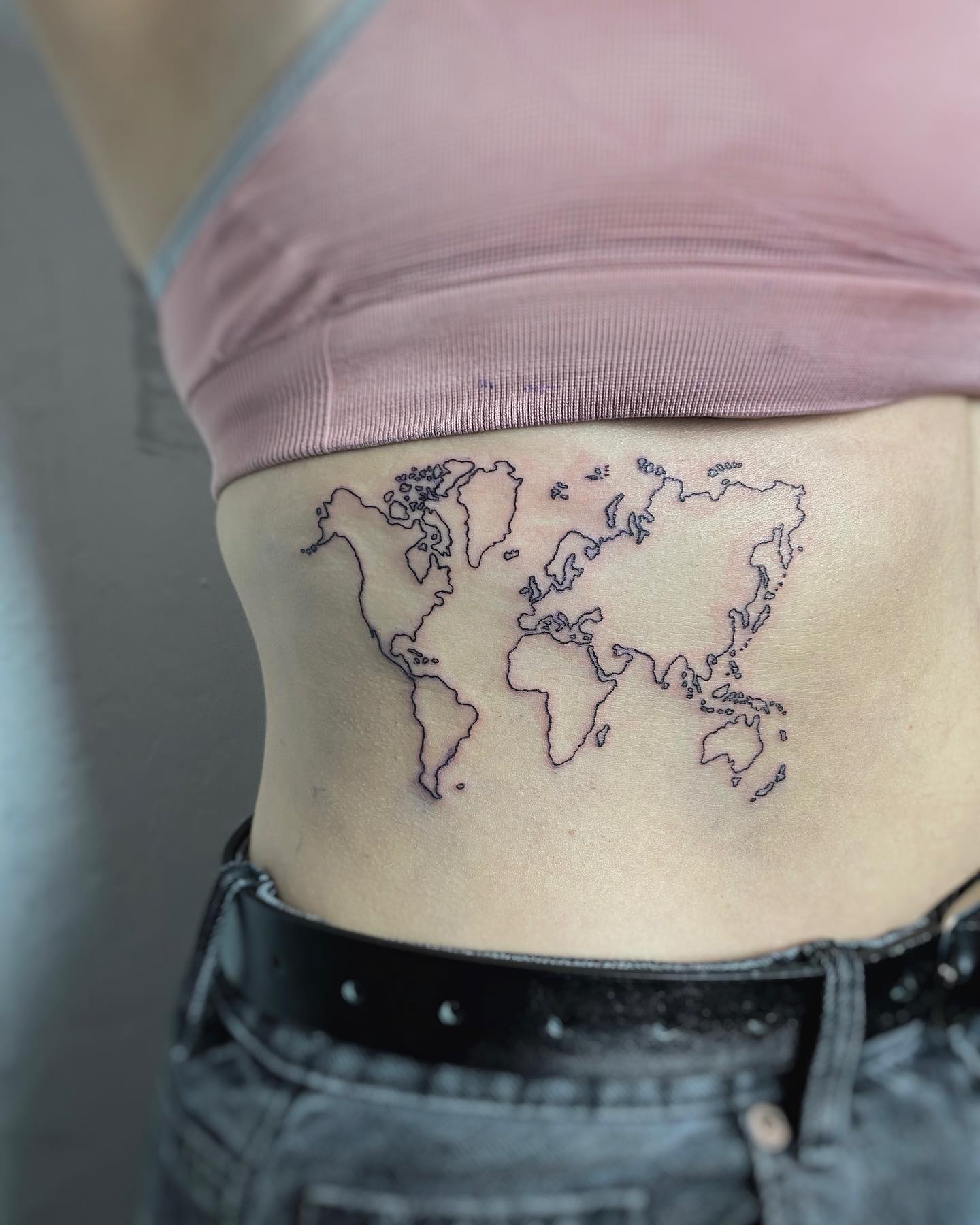 Tatuaje de costado con mapa mundial