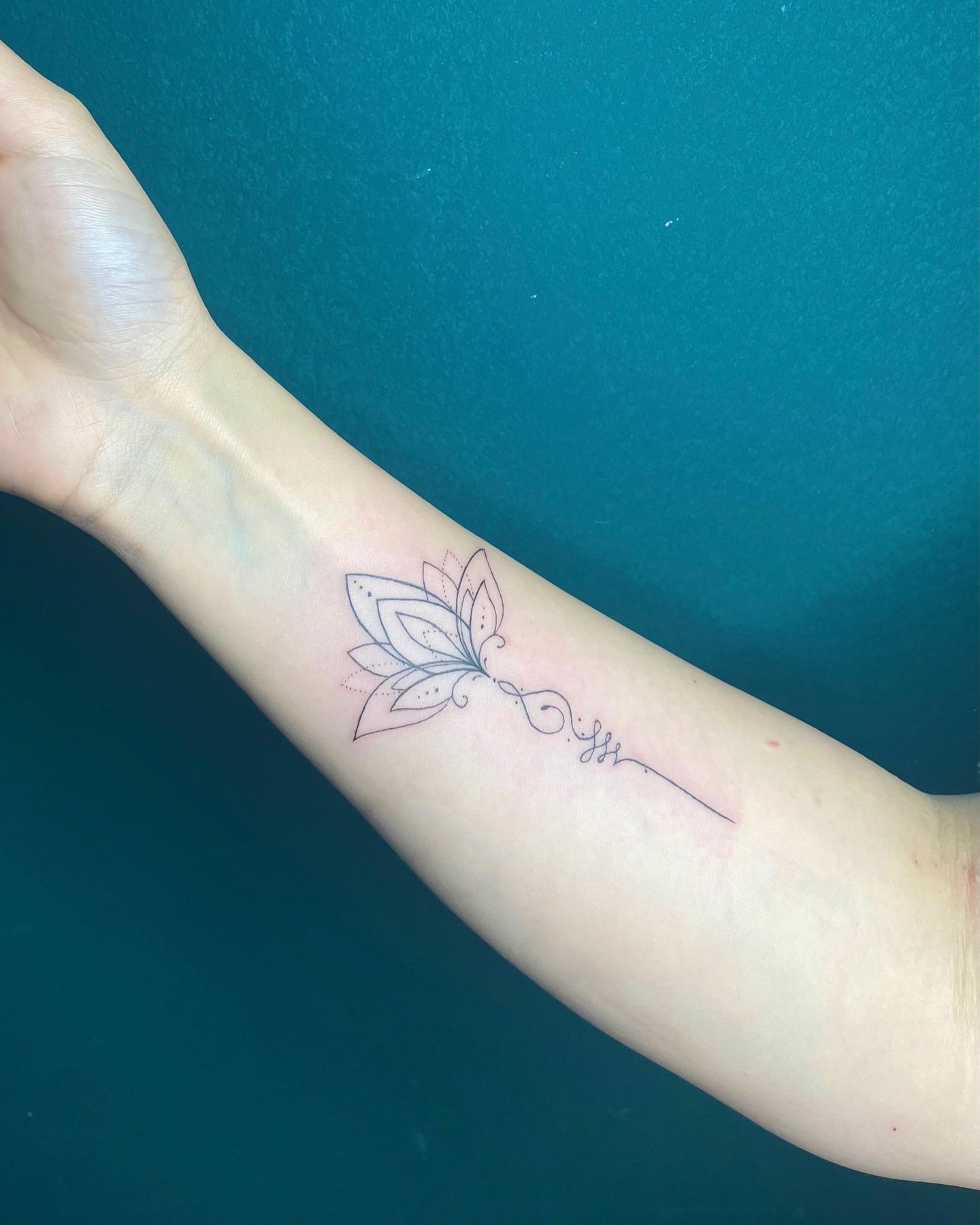 Tatuaje de flor de loto en la muñeca