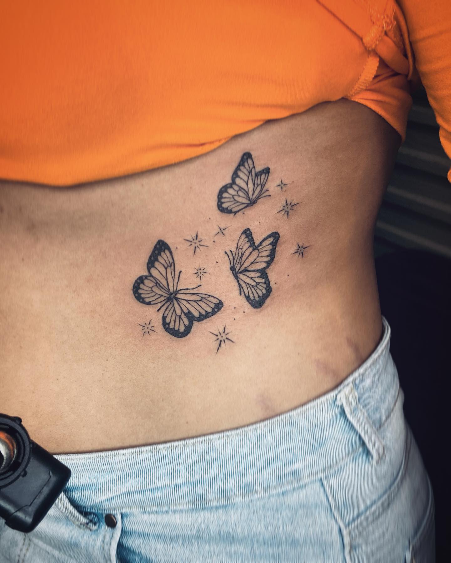 Tatuaje de mariposa lateral en las costillas