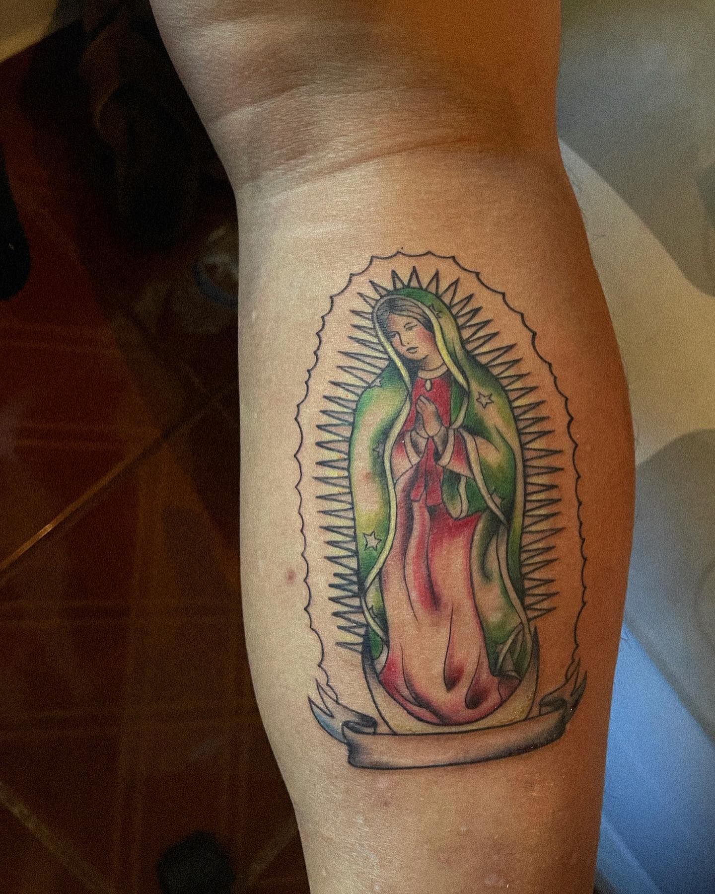 Pequeño tatuaje colorido de la Virgen de Guadalupe.