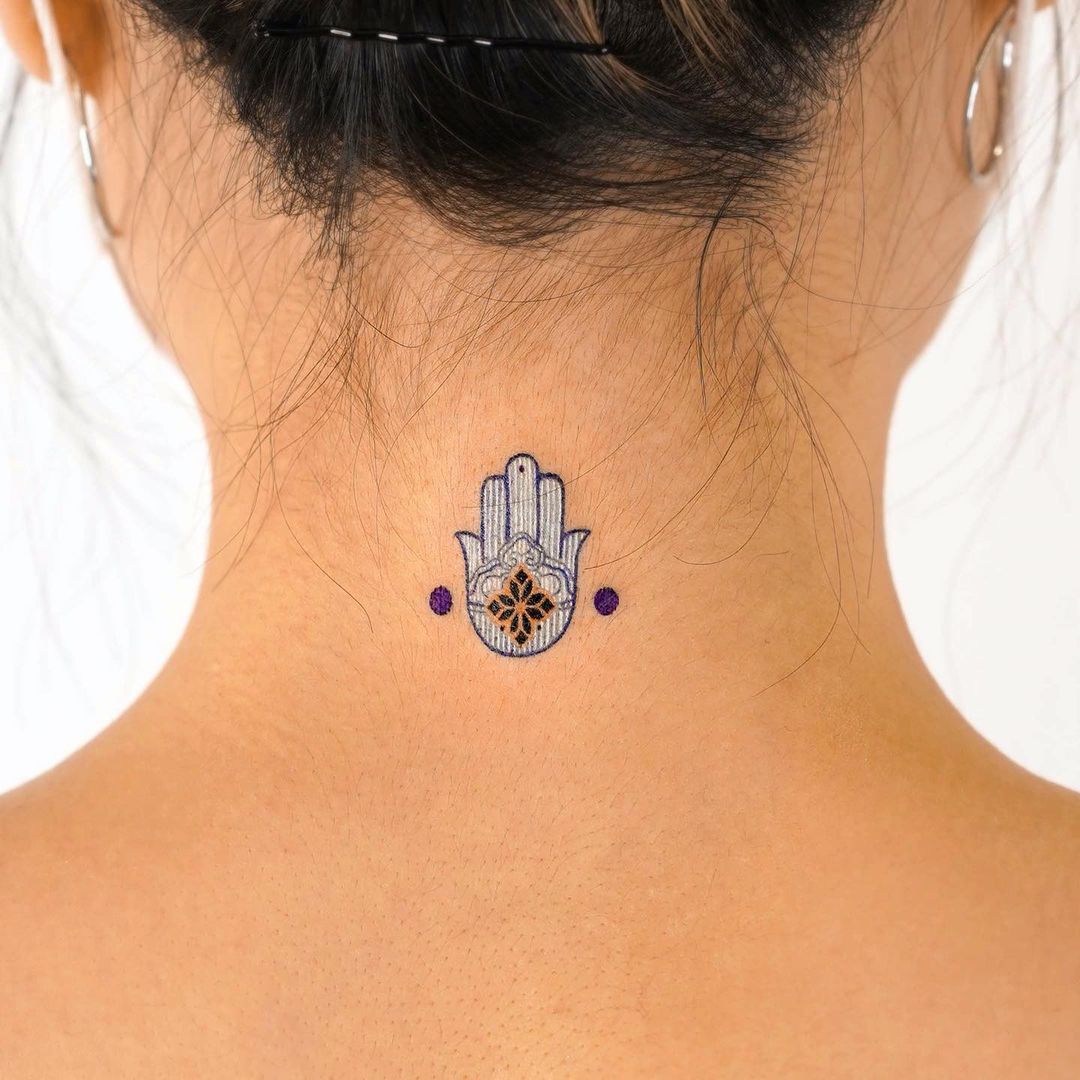 Pequeño tatuaje de Hamsa en el cuello.