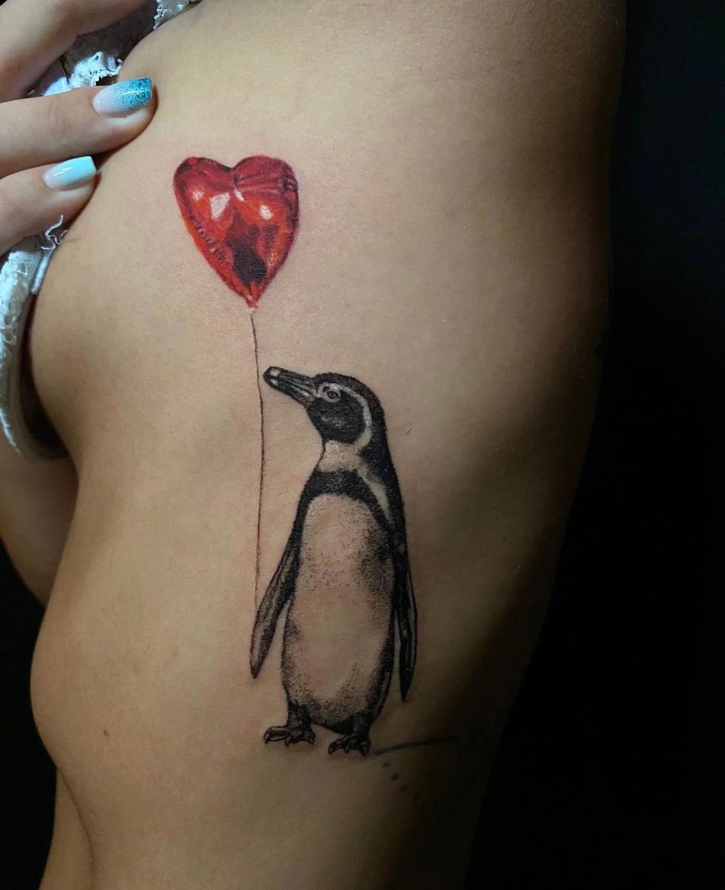 Pingüino con un tatuaje de globo
