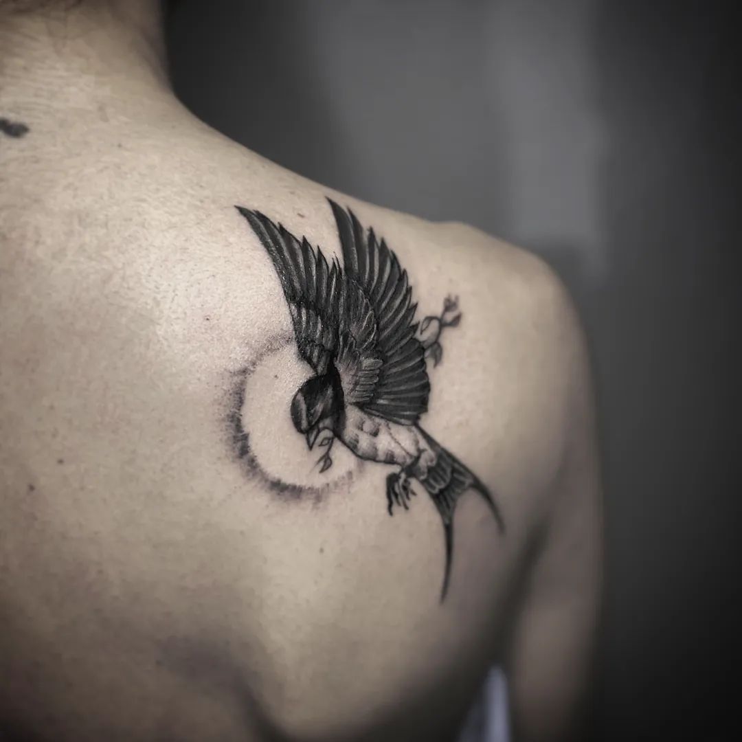 Tatuaje de espalda de pequeño pájaro para hombres.