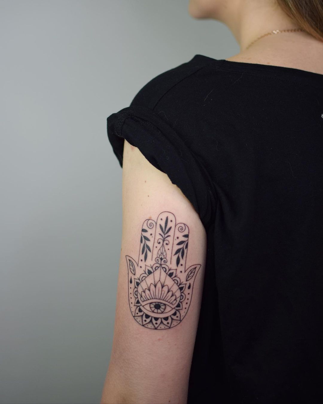 Tatuaje de Hamsa con tinta negra en el brazo